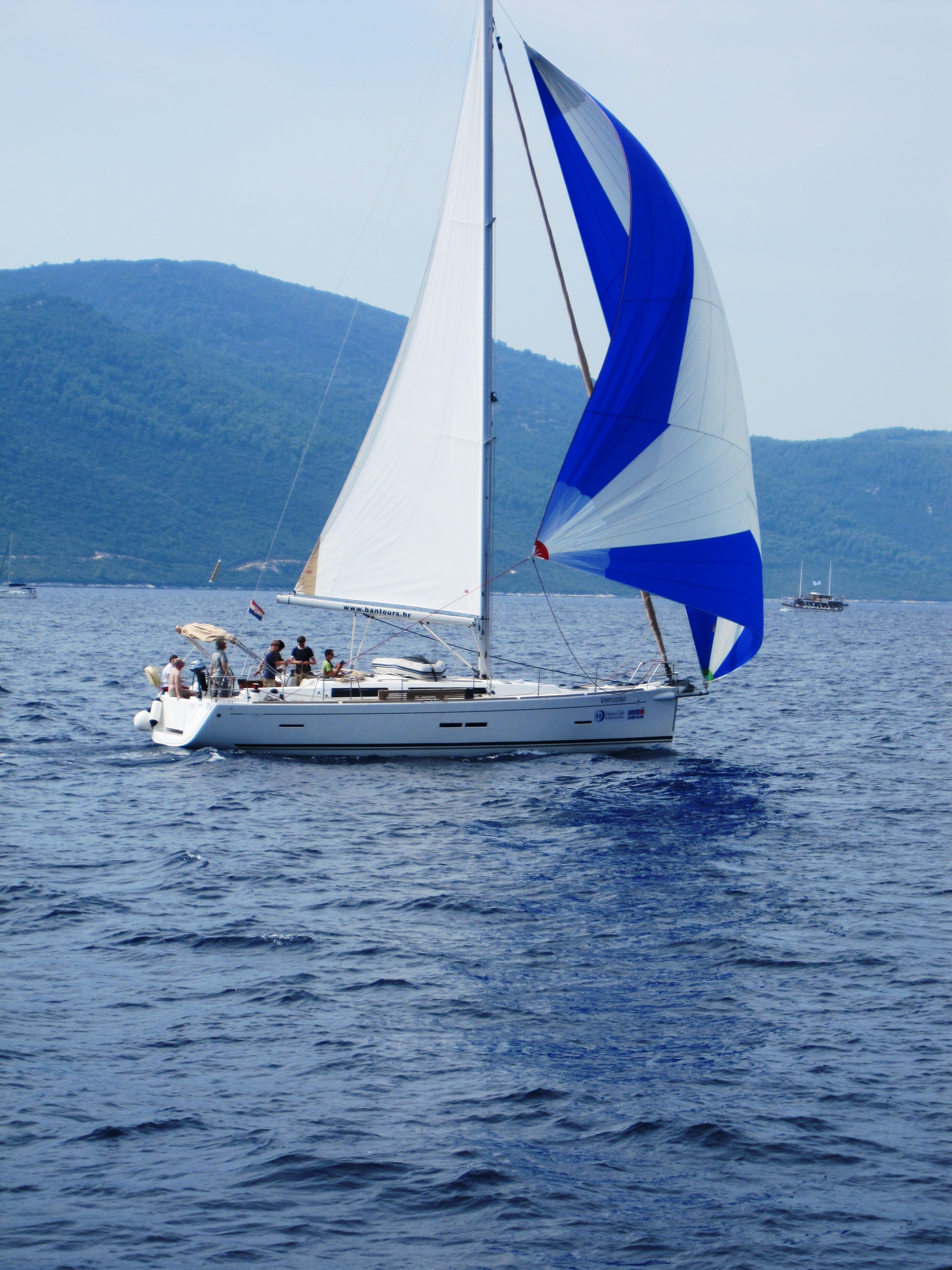 A sailing vessel under spinnaker on open water — the type of experiential passenger charter that existing national associations serve inconsistently